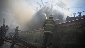 Petugas pemadam kebakaran melakukan pendinginan kapal nelayan yang terbakar di Dermaga Barat Pelabuahan Muara Baru, Jakarta, Sabtu (16/8/2025).