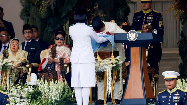 Presiden Prabowo Subianto (kanan) mencium duplikat Bendera Merah Putih saat diserahkan kepada Paskibraka pembawa baki Bianca Alessia Christabella untuk dikibarkan dalam Upacara Peringatan Detik-Detik Proklamasi Kemerdekaan ke-80 Republik Indonesia di