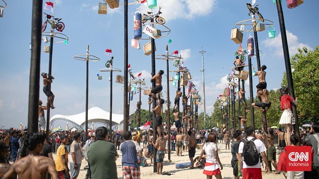 Dalam rangka menyemarakkan HUT ke-80 Republik Indonesia, Ancol Taman Impian menggelar lomba Panjat Pinang Kolosal di Pantai Beach Pool, Minggu (17/8/2025). (CNN Indonesia/Adi Maulana Ibrahim)
