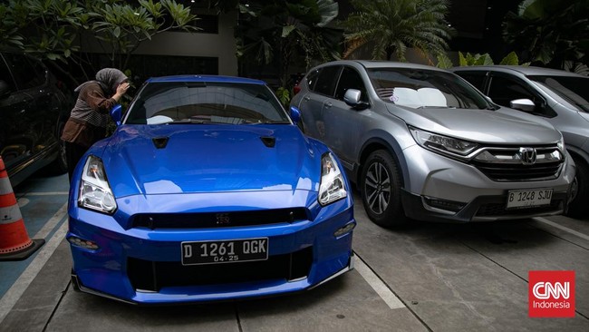 KPK memamerkan 15 mobil dan 7 motor sebagai barang bukti OTT Wamenaker Immanuel Ebenezer. Kendaraan mencolok ini menarik perhatian publik di Jakarta.