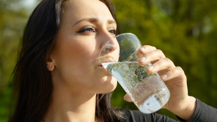 Ilustrasi soda diet Woman with glass of sparkling water, sunny summer day