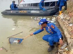 Personel Polda Riau Bersih-bersih Sampah di Tepian Narosa Arena Pacu Jalur