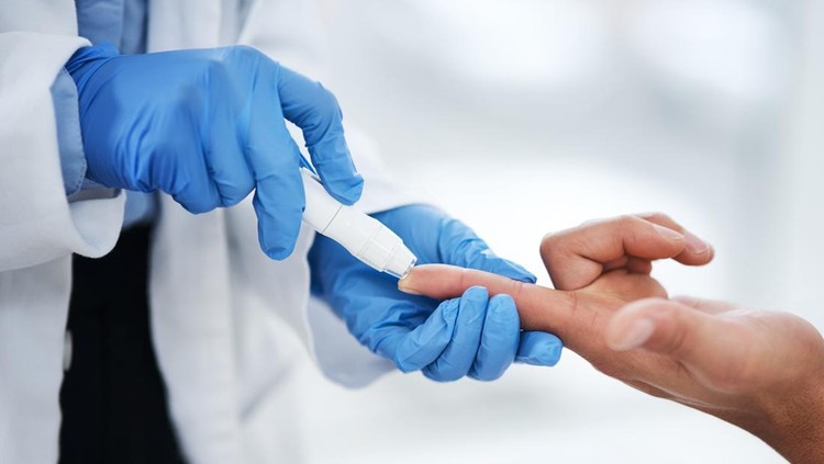 Shot of an unrecognisable doctor using a blood sugar test on his patient’s finger