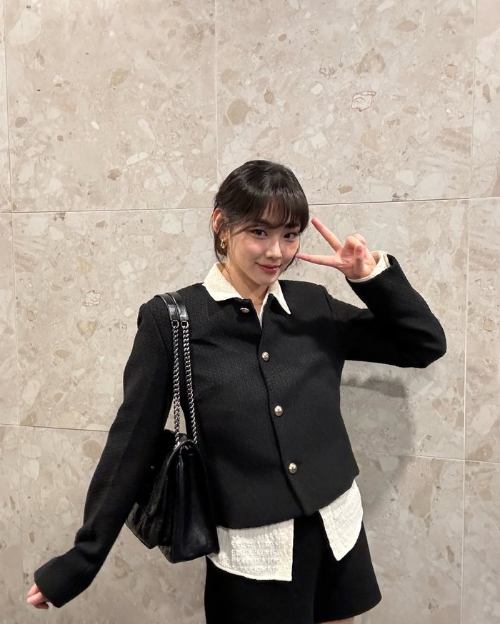 Tampil simpel namun tetap classy, ia memadukan kemeja putih dengan blazer hitam yang memiliki kancing besar sebagai detail dan menggunakan celana hitam pendek, super stylish abis, kan?/ Foto: Instagram.com/_happiness_o
