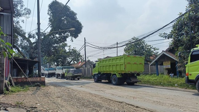 Truk tambang beroperasi siang hari di tengah renovasi jalan di Parung Panjang, Kabupaten Bogor.