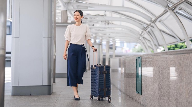 Ilustrasi turis di bandara Business adult asian woman walking with luggage for global trip. Female walking at station platform on day. People work and travel concept.