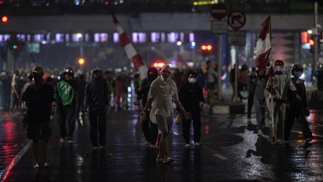 Massa aksi berkumpul di Mako Brimob setelah tewasnya ojol. Lalu lintas tersendat. Gas air mata masih tercium di lokasi.