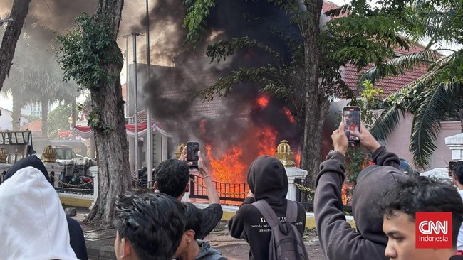 Bentrokan di Surabaya Pecah, Api Berkobar di Grahadi Bentrokan terjadi di Surabaya, Jumat (29/8), saat aksi protes kekerasan aparat setelah tewasnya pengemudi ojol Affan Kurniawan.