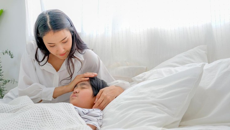 Ilustrasi kejang demam pada anak Asian mother take care her son during cold in bedroom with day light.