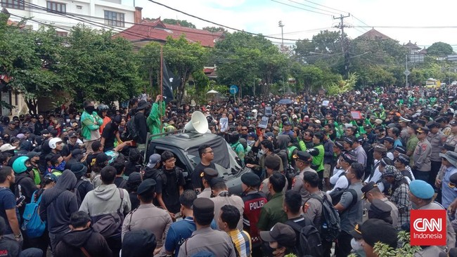 Massa Aksi Masih Bertahan di Polda Bali, Situasi Kondusif Massa aksi terus berunjuk rasa di depan Polda Bali, menuntut keadilan atas tewasnya pengemudi ojol Affan Kurniawan. Aksi berlangsung kondusif.