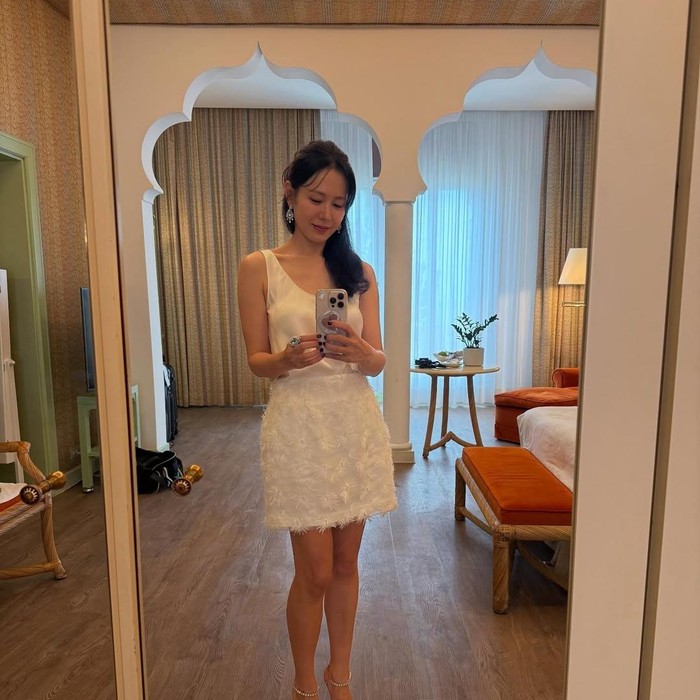 Dalam gaya lainnya, Son Ye Jin terlihat anggun dalam dress pendek berwarna putih. Terlihat clean sekaligus minimal.