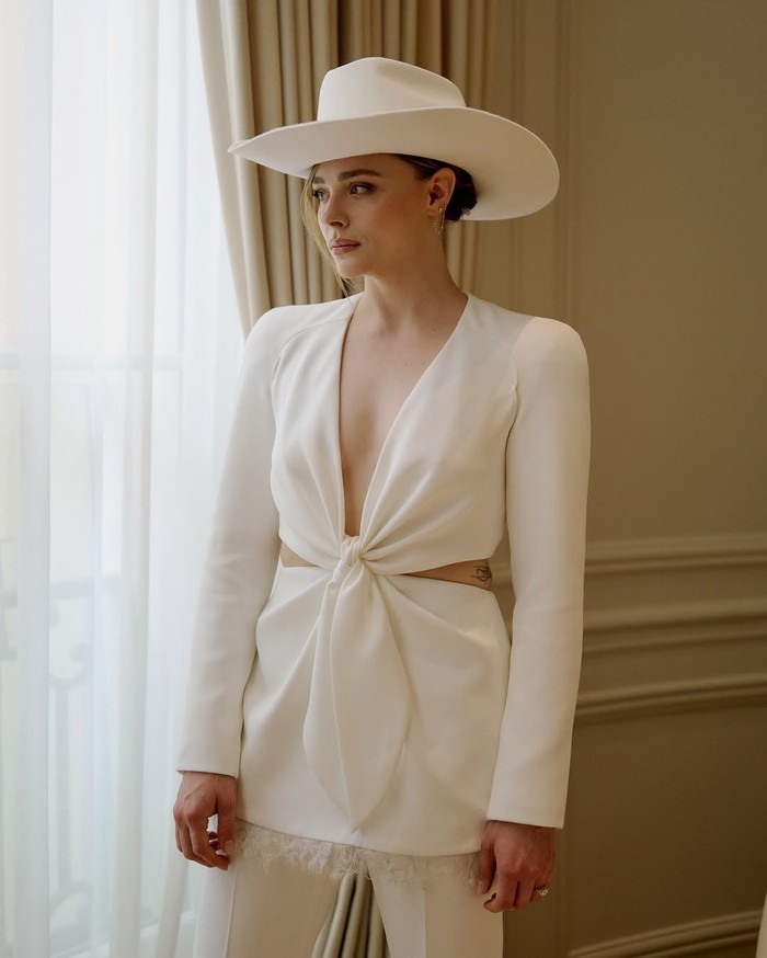 Chloe Grace Moretz pakai outfit putih di after-party pernikahannya. Nuansa monokromatik dengan sentuhan cowgirl.