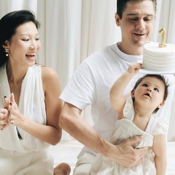 <p><em>Baby</em> Zoe pun tampil cantik dengan <em>dress</em>-nya yang senada dengan <em>outfit</em> kedua orang tuanya. Dengan rasa penasarannya, ia tampak gemas saat ingin memegang kue ulang tahun pertamanya. (Foto: Instagram @patriciagouw)</p>