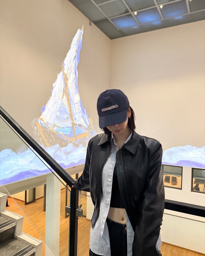 Edgy street style dengan leather jacket. Karina memamerkan sisi edgy dengan memadukan leather jacket hitam. Topi baseball hitam menambah sentuhan street style yang effortless dan kekinian./ Foto: instagram.com/katarinabluu