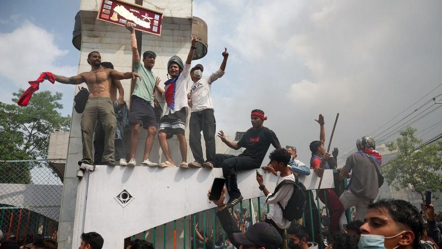 Para demonstran merayakan setelah memasuki kompleks Parlemen selama protes terhadap pembunuhan 19 orang pada hari Senin setelah protes antikorupsi yang dipicu oleh larangan media sosial, yang kemudian dicabut, selama jam malam di Kathmandu, Nepal, 9 September 2025. (REUTERS/Adnan Abidi)