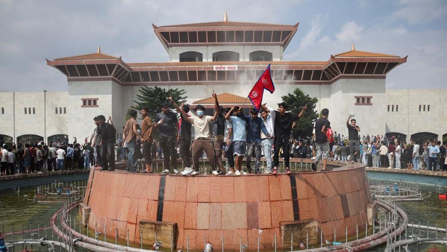 Para demonstran merayakan setelah memasuki kompleks Parlemen selama protes terhadap pembunuhan 19 orang pada hari Senin setelah protes antikorupsi yang dipicu oleh larangan media sosial, yang kemudian dicabut, selama jam malam di Kathmandu, Nepal, 9 September 2025. (REUTERS/Adnan Abidi)