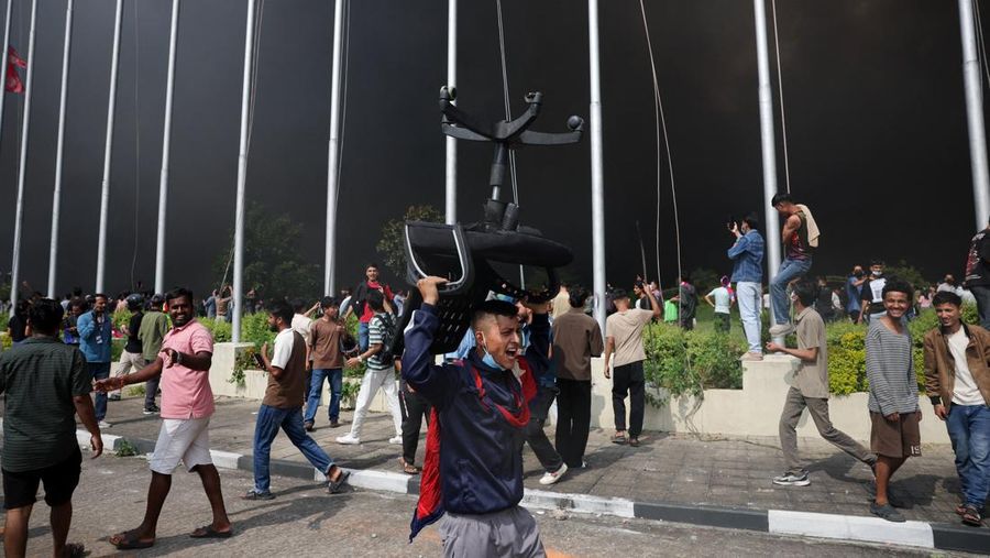 Para demonstran merayakan setelah memasuki kompleks Parlemen selama protes terhadap pembunuhan 19 orang pada hari Senin setelah protes antikorupsi yang dipicu oleh larangan media sosial, yang kemudian dicabut, selama jam malam di Kathmandu, Nepal, 9 September 2025. (REUTERS/Adnan Abidi)