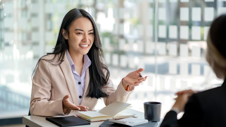 Ilustrasi HRD interview calon pegawai Two young Asian business woman talk, consult, discuss working with new startup project idea presentation analyze plan marketing and investment in the office.