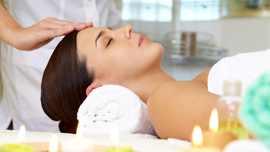 Portrait of young female enjoying the procedure of facial massage