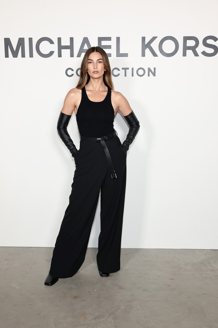Lily Aldridge menampilkan all-black look yang berkesan daring dan tough. Casmere body suit dipadu padan dnegan celana panjang wool di mana keduanya merupakan koleksi Michael Kors Fall/Winter 2025. Ikat pinggang dan opera gloves senada menguatkan drama./ Foto: Courtesy of Michael Kors/Getty Images for Michael Kors/Jamie McCarthy