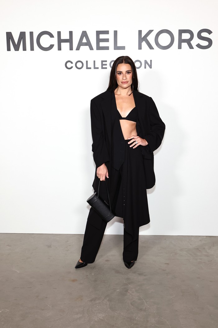 Kesan serupa ditampilkan oleh Lea Michele yang berani mengenakan bra top. Ryan blazer berbahan wool dari Michael Kors dikombinasi bawahan trouser dengan lapisan rok yang stylish. OOTD ini tersedia dalam koleksi Michael Kors Fall/Winter 2025/ Foto: Courtesy of Michael Kors/Getty Images for Michael Kors/Jamie McCarthy