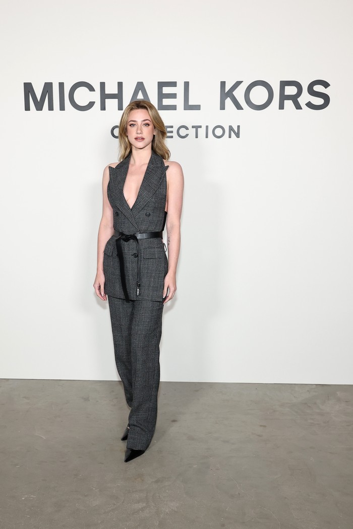 Setelan plaid yang membalut Lili Reinhart buat tampilannya tampak semi-formal, tapi tetap stylish, Beauties. Potongan garis leher halter yang rendah pada vest beri sentuhan seksi. Outfit ini merupakan koleksi Michael Kors Fall/Winter 2025/ Foto: Courtesy of Michael Kors/Getty Images for Michael Kors/Jamie McCarthy