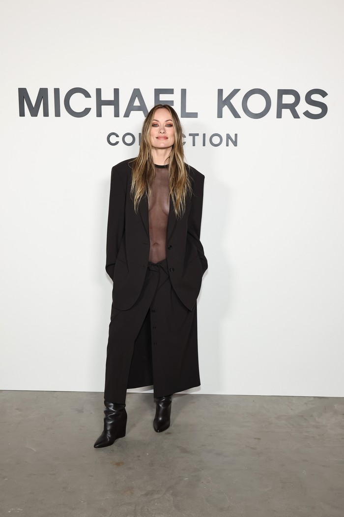 Outfit see-through kembali naik daun akhir-akhir ini, Beauties! Salah satu yang memakainya adalah Olivia Wilde saat hadiri fashion show Michael Kors. Sheer-viscose bodysuit ditumpuk dengan blazer wool serta dipasangkan dengan trouser skirt yang matching/ Foto: Courtesy of Michael Kors/Getty Images for Michael Kors/Jamie McCarthy