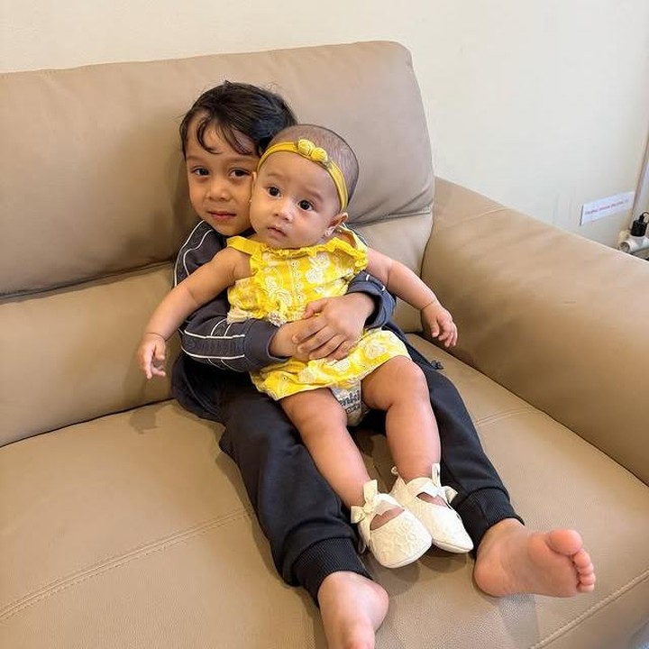 <p>Dalam salah satu momen, Levian terlihat memeluk Leshia sambil tersenyum manis. Si Kecil yang baru berusia 7 bulan ini kelihatan nyaman sekali di pelukan sang kakak. Dengan ekspresi polosnya, Levian benar-benar sukses bikin siapa pun yang melihatnya ikut tersenyum. (Foto: Instagram @leshiativana)</p>