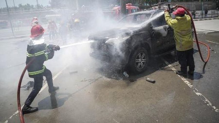 A firefighter extinguishes a blaze set alight by university students protesting the parliaments plan to buy 65 SUVs for lawmakers in Dili, East Timor, on September 16, 2025. East Timor police fired tear gas on September 16 at protesters railing for the second day against a plan to buy new official cars for lawmakers, which became the latest flashpoint in one of the poorest nations in Southeast Asia. (Photo by VALENTINO DARIELL DE SOUSA / AFP)