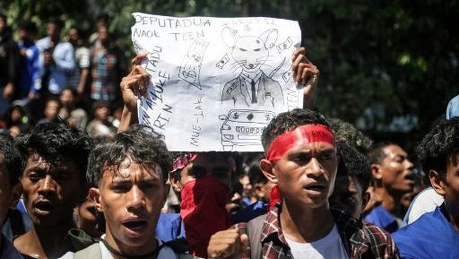 A firefighter extinguishes a blaze set alight by university students protesting the parliaments plan to buy 65 SUVs for lawmakers in Dili, East Timor, on September 16, 2025. East Timor police fired tear gas on September 16 at protesters railing for the second day against a plan to buy new official cars for lawmakers, which became the latest flashpoint in one of the poorest nations in Southeast Asia. (Photo by VALENTINO DARIELL DE SOUSA / AFP)