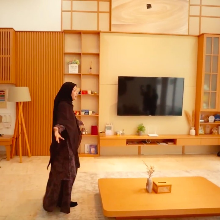 <p>Sudut yang cukup menarik perhatian di rumah ini adalah ruang tamu atau ruang keluarga. Natasha Rizky banyak menggunakan ornamen dan furnitur bergaya minimalis Jepang dengan sentuhan kayu cokelat, seperti di tempat rak buku hingga meja ala Jepang. "Sekarang aku bikin temanya itu lebih ke minimalis Jepang, karena aku kan lagi suka banget sama Jepang. Jadi aku ingin semua detailnya ke Jepang-Jepangan," ungkap Natasha Rizky. (Foto: YouTube Trio Strong Family)</p>