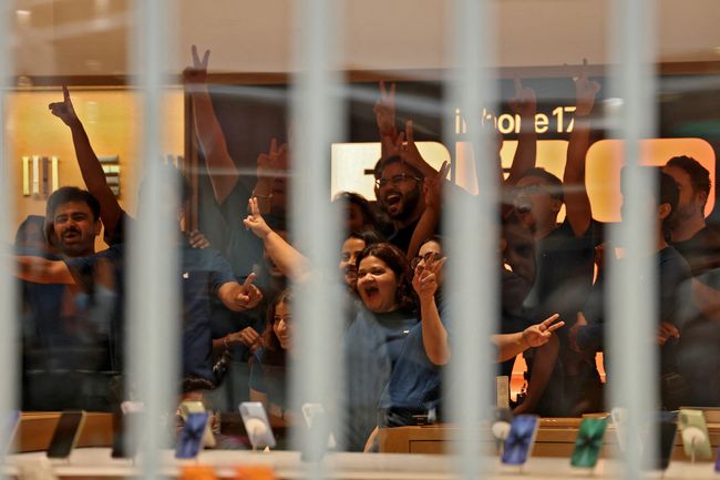 Orang-orang menunggu dalam antrian di luar toko ritel Apple, New Delhi, India, Jumat (19/9/2025). (REUTERS/Bhawika Chhabra)