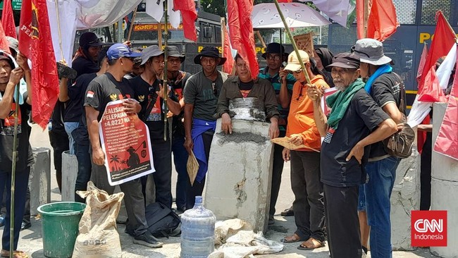 Dalam aksi peringatan Hari Tani, salah satu massa aksi melakukan cor badan sebagai bentuk protes atas kekecewaan petani terkait reformasi agraria.
