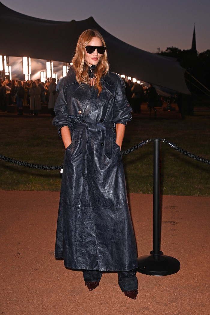 Serahkan pada Rosie Huntington-Whiteley untuk buat gaya simpel jadi fashion-forward. Trench coat hitam bermaterial leather di-styling dengan kalung choker, sunglasses hitam, dan juga pointy shoes coklat/ Foto: Courtesy of Burberry/Dave Benett/Dave Benett