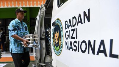 Petugas Badan Gizi Nasional membawa tempat makan program MBG di SMPN 28 Johar Baru, Jakarta, Selasa (23/9/2025). Pemprov DKI Jakarta membuat inovasi Sekolah Laboratorium Pancasila (SLP) untuk meningka