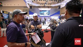 Pengunjung melihat sepeda motor yang dipamerkan dalam Pameran Indonesia Motorcycle Show (IMOS) 2025 di Indonesia Convention Exhibition (ICE) BSD, Serpong, Kabupaten Tangerang, Banten, Kamis (25/9/2025). (CNN Indonesia/Adi Ibrahim)