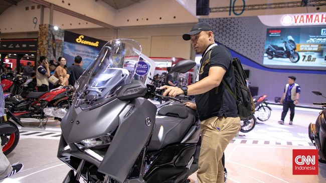 Pengunjung melihat sepeda motor yang dipamerkan dalam Pameran Indonesia Motorcycle Show (IMOS) 2025 di Indonesia Convention Exhibition (ICE) BSD, Serpong, Kabupaten Tangerang, Banten, Kamis (25/9/2025). (CNN Indonesia/Adi Ibrahim)