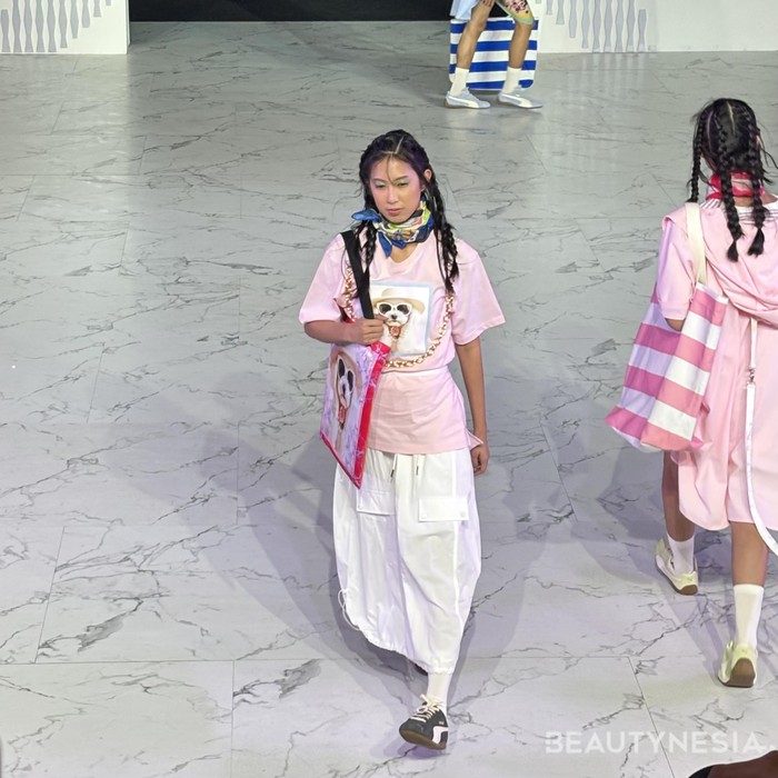 Salah satu koleksinya, memadukan t-shirt berwarna pink cerah dengan cargo skirt berwarna putih. Tambahan scarf dan tote bag, serta chain necklace membuat tampilan lebih bergaya dan kekinian. (Foto: Rini Apriliani/Beautynesia)