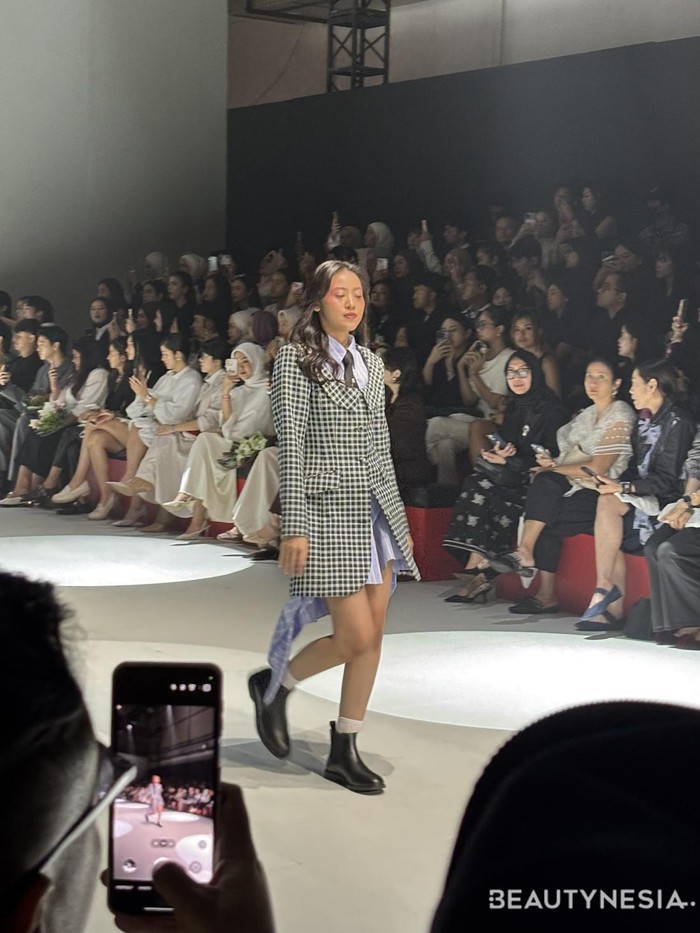 Salah satu koleksinya adalah kemeja oversized berwarna biru muda bermotif garis vertikal, dipadukan dengan blazer motif gingham dengan kerah peter pan yang menampilkan kesan lebih muda dan cute. (Foto: Rini Apriliani/Beautynesia)