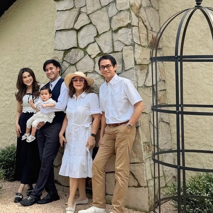 <p>Selama berlibur, keluarga kecil ini tampil kompak dengan busana senada yang membuat potret mereka makin terlihat serasi. Kimova tampak menggemaskan ketika digendong oleh sang Ayah, Kevin. (Foto: Instagram @vicymelanie)</p>