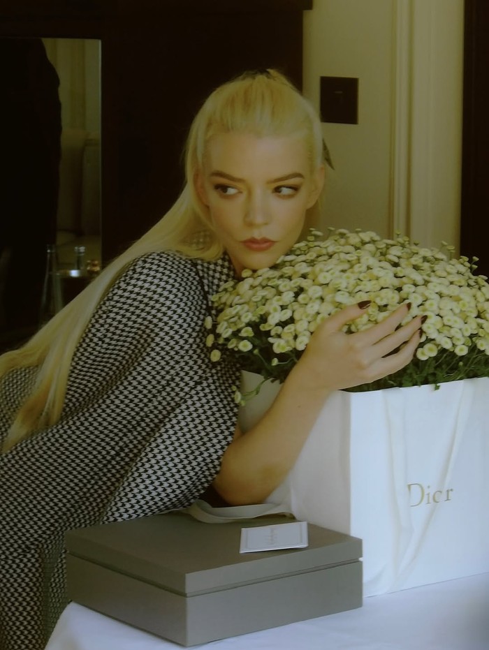 Anya Taylor-Joy tampil stylish saat hadiri show Dior dengan cape houndstooth hitam-putih, mini skirt serasi, dan waistcoat halter-neck putih, dipadukan heels hitam/Foto: instagram.com/anyataylorjoy