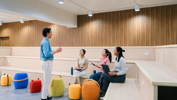 A diverse group of professionals collaborates on a project in a spacious&comma; modern office&period; Showcasing teamwork&comma; casual interaction&comma; and creativity in a bright workspace&period;