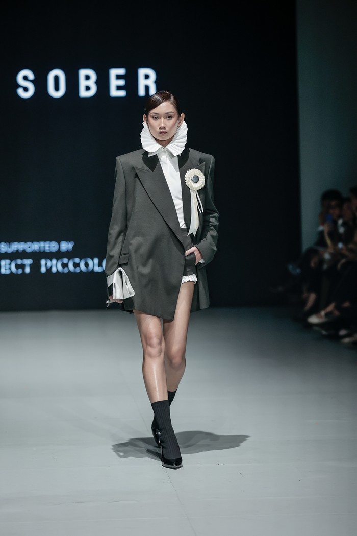 Jas ditampilkan dengan potongan oversized, tapi tetap feminin dan modern melalui detail. Sementara kemeja high collar dirancang dengan tekstur lipit yang beri drama sekaligus kesan klasik/ Foto: Dok. PILLAR
