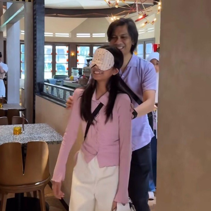 <p>Menilik lewat unggahan di Instagram istri Tria, Dhatu Rembulan membagikan momen saat merayakan ulang tahun Lenonina. Dalam video yang dibagikan, tampak sang putri mendapatkan kejutan manis yang ditemani langsung oleh sang Ayah. Sambil ditutup matanya, Lenon nampak dituntun oleh ayahnya. (Foto: Instagram @dhaturembulan)</p>
