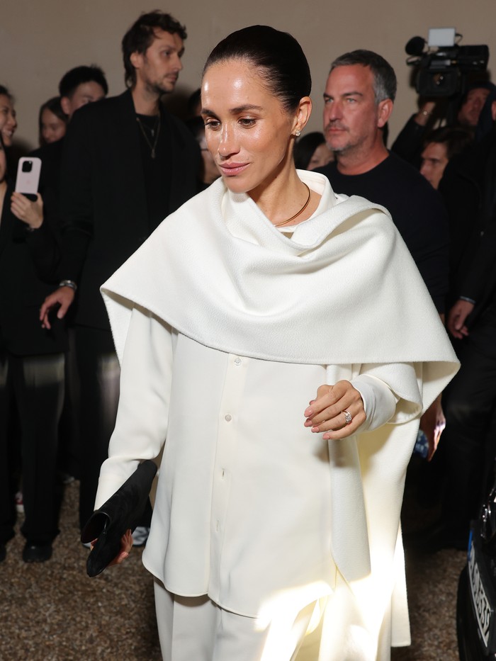 Meghan Markle tampil dalam gaya andalannya: monokromatik. Elegan, kemeja dan wide-leg pants dipadu dengan cape scarf seluruhnya dalam warna putih/ Foto: Courtesy of Balenciaga/Getty Images for Balenciaga/Arnold Jerocki
