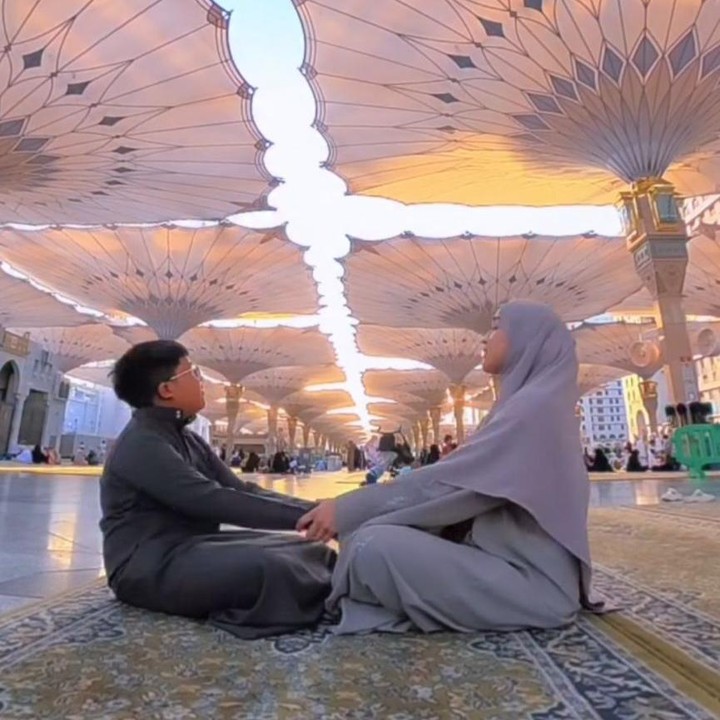 <p>Ririe dan sang putra tampaknya begitu menikmati setiap momen saat berada di Masjid Nabawi. Misalnya saja seperti momen berikut ketika mereka menunggu payung-payung raksasa yang ikonik terbuka.&nbsp;&nbsp;(Foto: Instagram@ririe_fairus)</p>