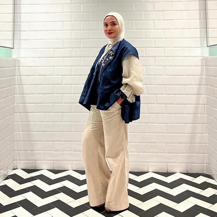 <p>Baru-baru ini, Enno membagikan potret gaya penampilannya yang kasual namun terlihat formal. Enno tampil <em>stylish</em> mengenakan vest jeans dengan motif bunga yang dipadukan dengan baju, celana, dan hijab berwarna putih gading. (Foto: Instagram @ennolerian_)</p>