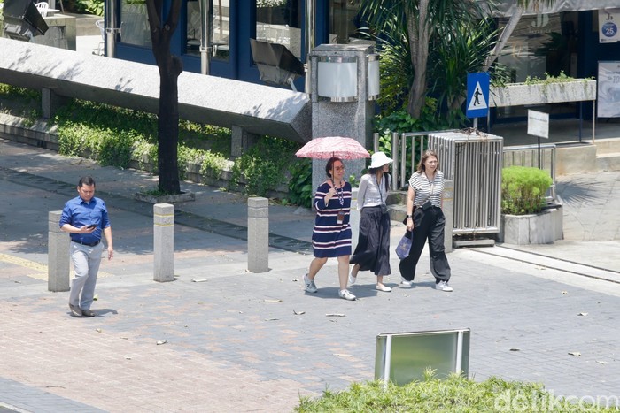 Sejumlah warga beraktivitas di luar ruangan di bawah teriknya matahari, Jakarta, Selasa (14/10/2025).