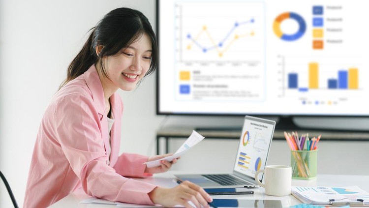 Ilustrasi magang atau karyawan Smiling millennial Asian female office worker working with financial reports for tax audit reports or financial statement in a meeting room
