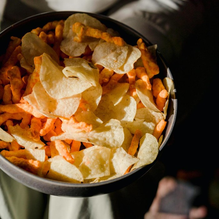 Menurut ahli diet, sebaiknya hindari kebiasaan menikmati camilan dari bungkusnya langsung. Kebiasaan ini bisa membuatmu jadi kalap dan tidak sadar berapa banyak yang telah kamu nikmati sambil bermain HP atau menonton TV.